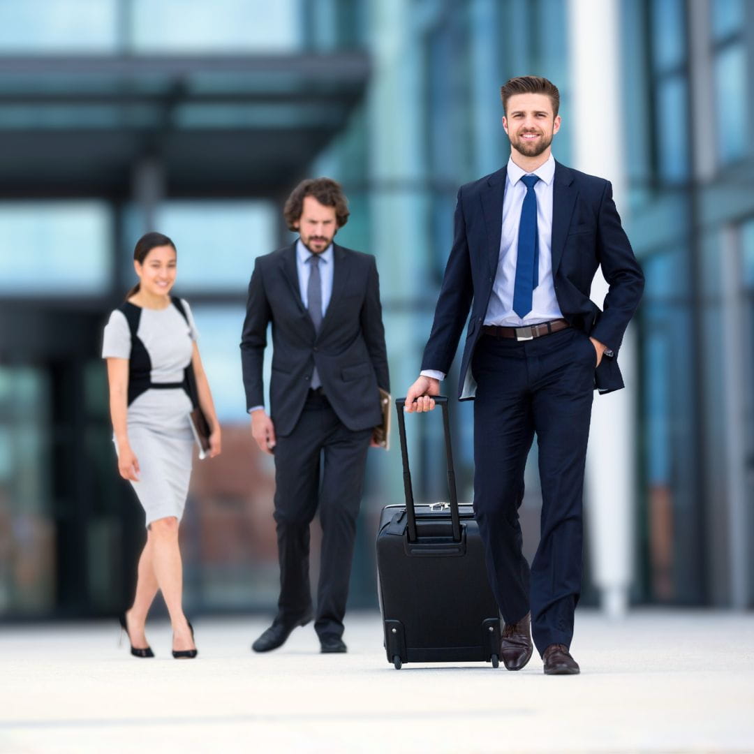 Corporate professionals exiting an airport terminal with luggage for a MICE incentive charter trip.